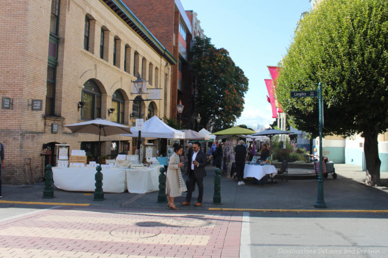 Outdoor vendors in a wide alley in downtown Victoria