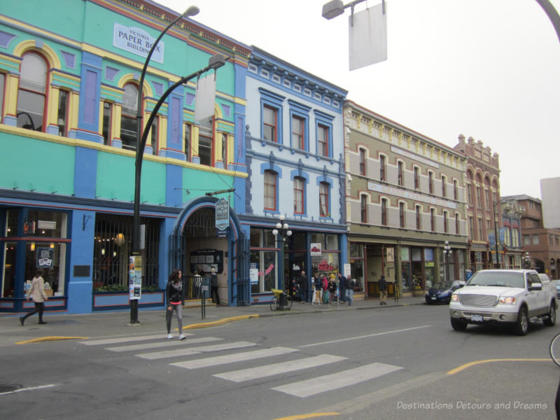 Victoria Johnson Street Historic Buildings Blue, green, tan, and red buildings dating to the late 1800s in downtown Victoria