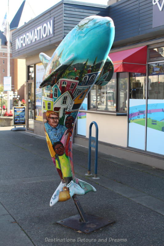 Orca whale sculpture with a painted mural on it