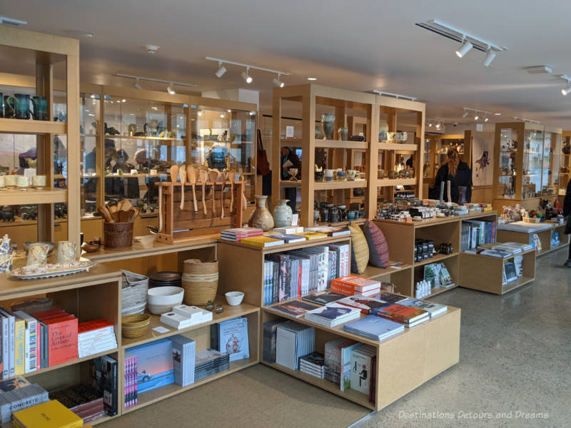 Row of shelves in WAG art gallery shop contain books, cushions, pottery, Inuit carvings, and other gift items