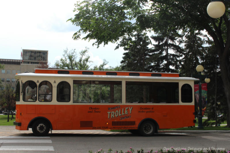 Orange and white trolley-style bus offering sightseeing tours of Winnipeg, Manitoba 