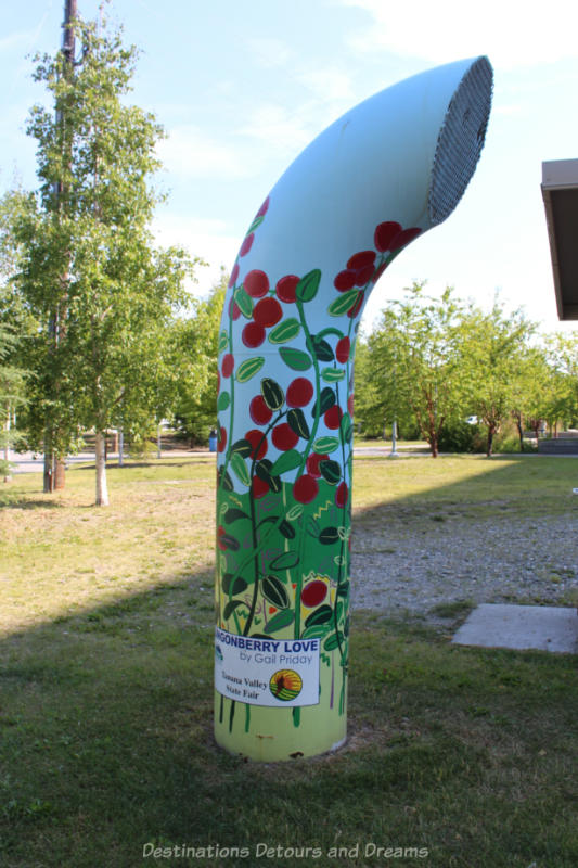 Painting of ligonberries on a steam vent in a downtown park