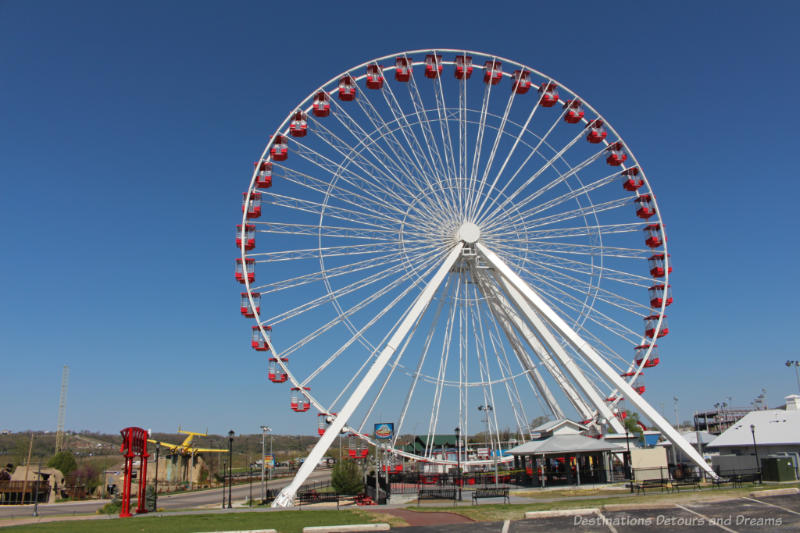 Large white ferris wheel with red cars along the Branson Strip