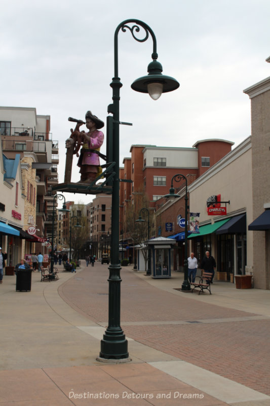 Wide pedestrian street with shops on either side and interesting lamp poles in Branson Landing, Missouri