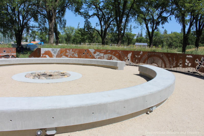 Circular cement seating around a fire pit in the Indigenous Peoples Garden at The Leaf in Winnipeg, Manitoba