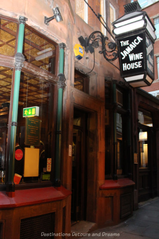 Dark wood front and door into lively pub that was once a 1652 coffee house in London, now the Jamaica Wine House