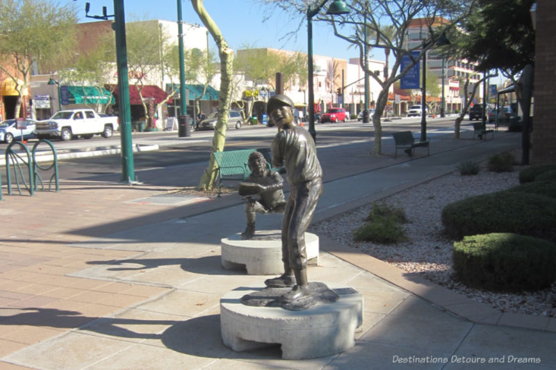 Two bronze baseball players, part of Big League Dreams, on display in downtown Mesa
