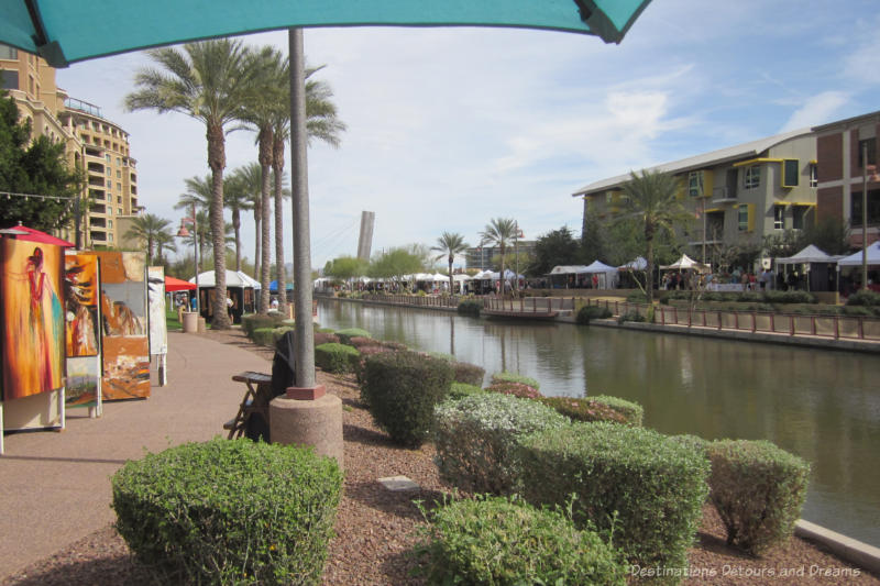 Canal waterfront with walkways on either side lines with festival tents in Scottsdale