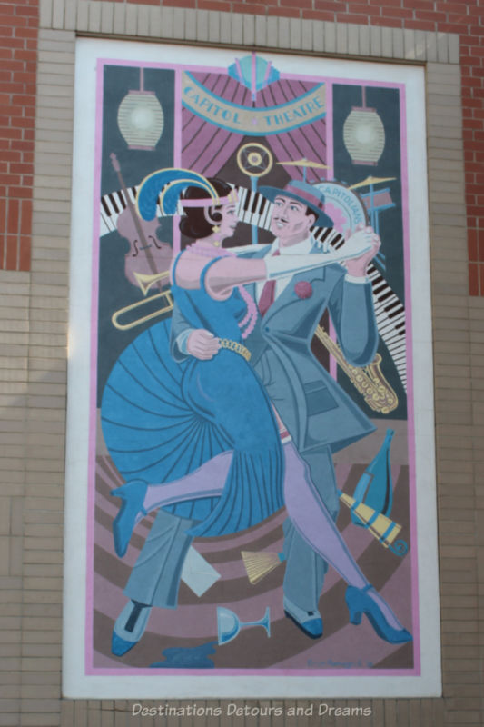 Mural shows 1920s dancing couple with a collage of instruments and party items in the background