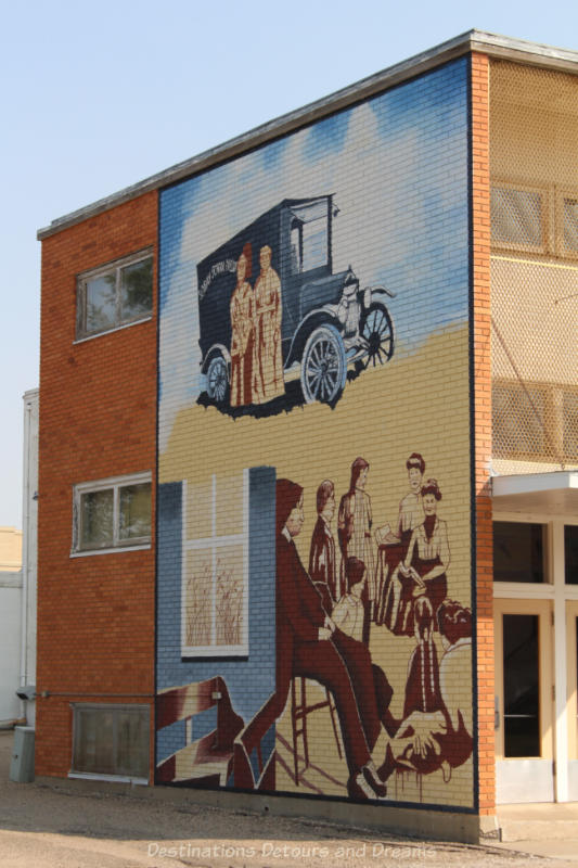 Mural shows a 1920s Sunday School group is sepia tones and a couple of women in front of 1920s era blue car