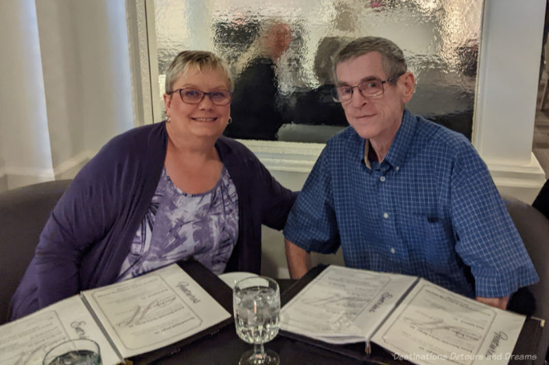 A woman and man at a dining table with menus in front of them